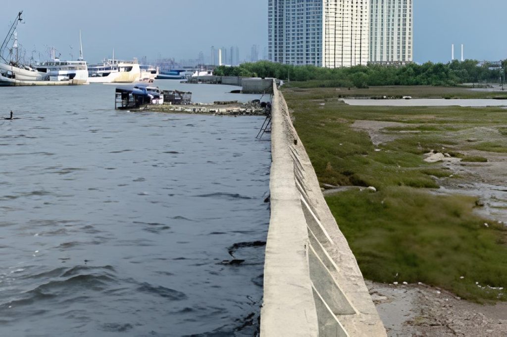Foto tanggul di Jakarta yang memperlihatkan air laut lebih tinggi daripada daratan oleh Kompas.com